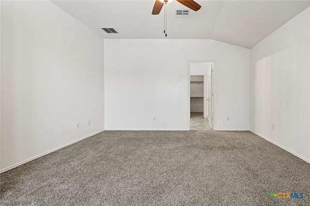 empty room featuring carpet floors, vaulted ceiling, and ceiling fan