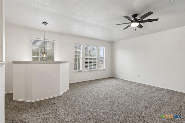 unfurnished room with ceiling fan, a textured ceiling, and dark colored carpet