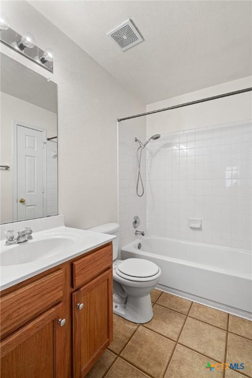 full bathroom featuring bathtub / shower combination, toilet, vanity, and tile patterned flooring