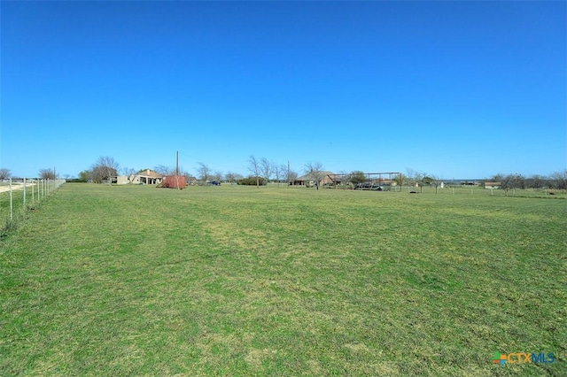 view of yard featuring a rural view and fence