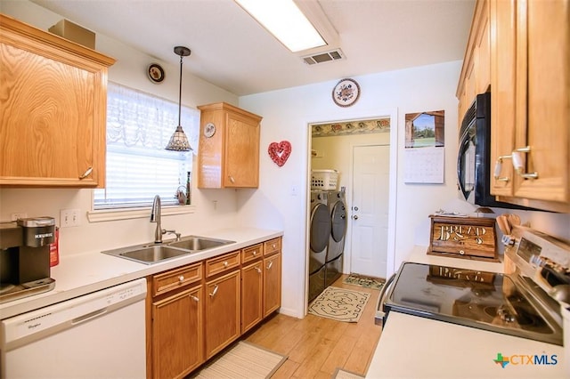 kitchen featuring visible vents, black microwave, dishwasher, stainless steel range with electric cooktop, and a sink