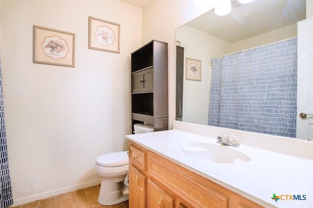 full bath featuring toilet, vanity, and baseboards