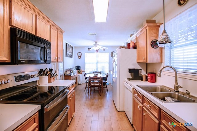 kitchen featuring a sink, black microwave, light countertops, range with two ovens, and dishwasher