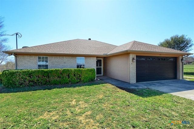 single story home with a front yard, an attached garage, a shingled roof, concrete driveway, and brick siding