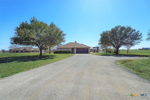 single story home featuring a front yard, an attached garage, and aphalt driveway