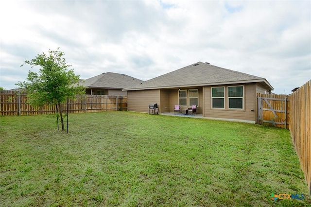 back of house with a yard, a patio area, and a fenced backyard