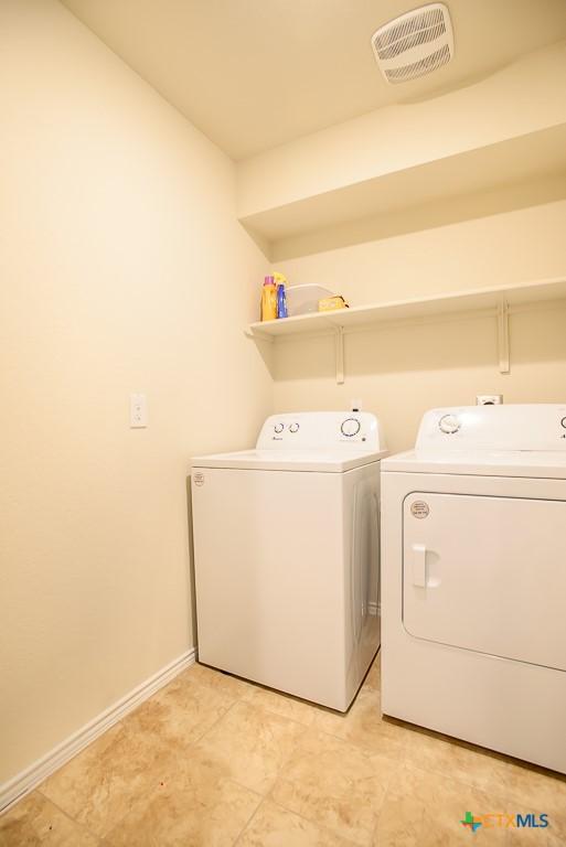 laundry room with visible vents, washer and clothes dryer, baseboards, and laundry area