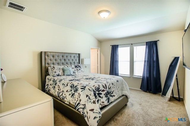 bedroom featuring vaulted ceiling, visible vents, baseboards, and light carpet