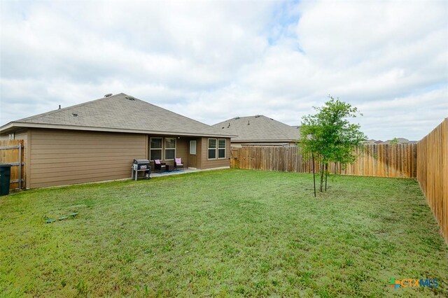 back of property featuring a fenced backyard, a patio area, and a lawn