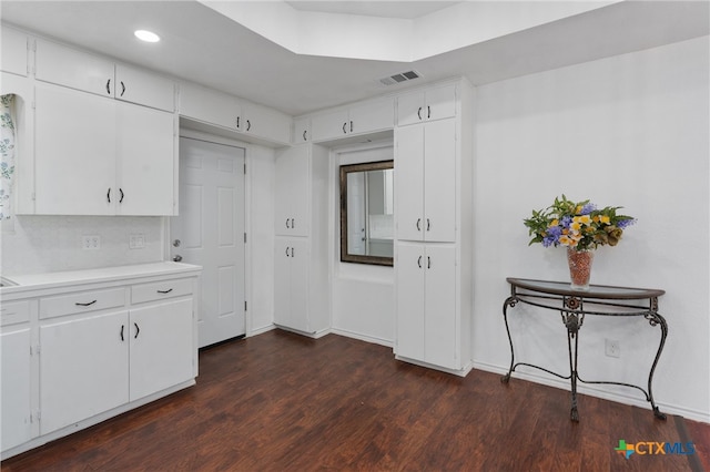 kitchen featuring white cabinets, decorative backsplash, and dark hardwood / wood-style floors