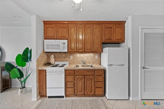 2 Cliffhouse Dr Unit 103, Belton, TX 76513 - kitchen featuring white appliances, a sink, light tile patterned flooring, brown cabinets, and light countertops
