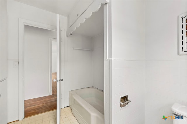 bathroom featuring a bathing tub and tile walls