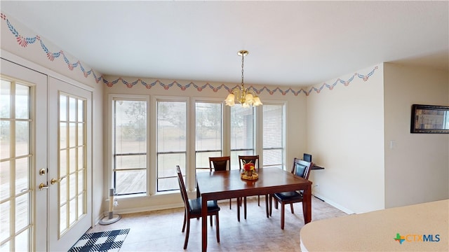 tiled dining room featuring french doors and a chandelier