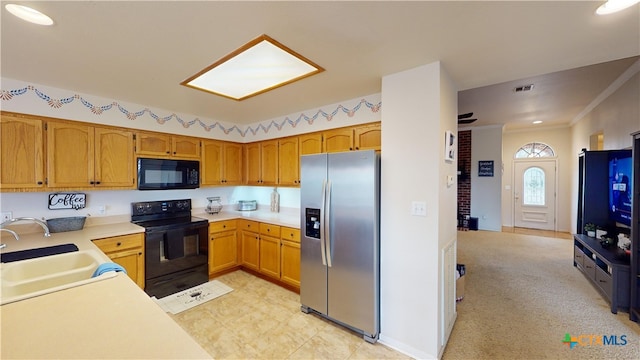 kitchen featuring black appliances, crown molding, and sink