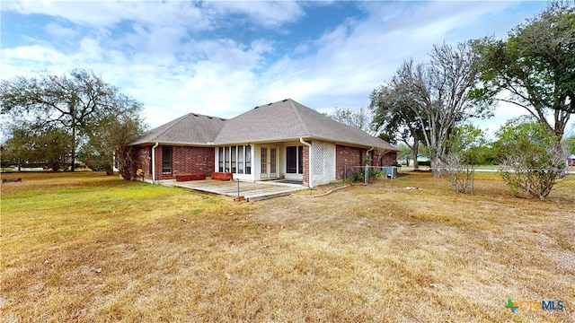 rear view of house with a lawn and a patio area