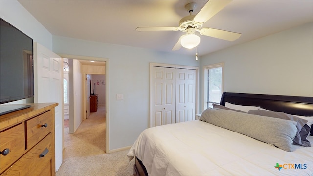 bedroom featuring ceiling fan, light colored carpet, and a closet