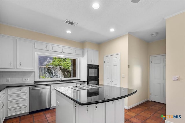 6013 Country Club Dr, Victoria, TX 77904 - kitchen featuring dishwasher, white cabinets, tasteful backsplash, dark countertops, and cooktop