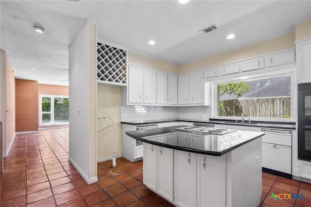 6013 Country Club Dr, Victoria, TX 77904 - kitchen featuring white stovetop, a kitchen island, white cabinetry, decorative backsplash, and recessed lighting