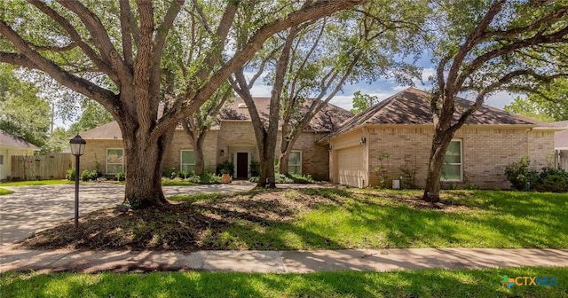 6013 Country Club Dr, Victoria, TX 77904 - view of front of house featuring brick siding, a garage, and a front lawn