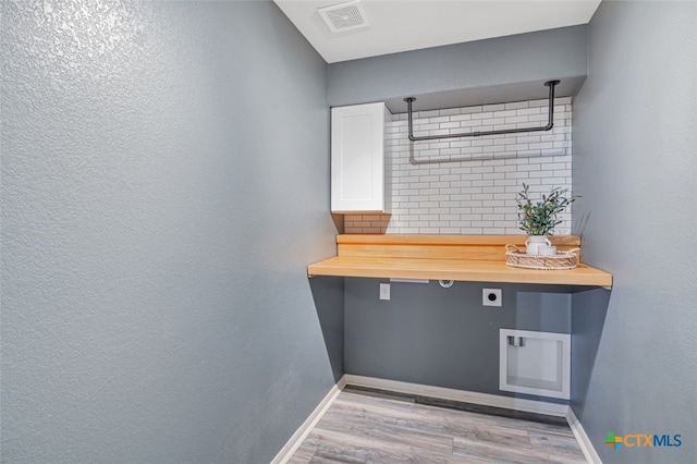 506 Old Peak Rd, Georgetown, TX 78626 - laundry view of wood finished floors, baseboards, and tasteful backsplash