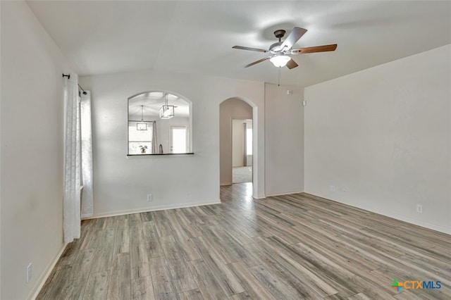 506 Old Peak Rd, Georgetown, TX 78626 - spare room with arched walkways, a ceiling fan, wood finished floors, and baseboards