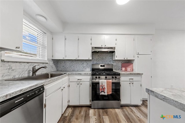 kitchen featuring appliances with stainless steel finishes, sink, white cabinets, and light wood-type flooring