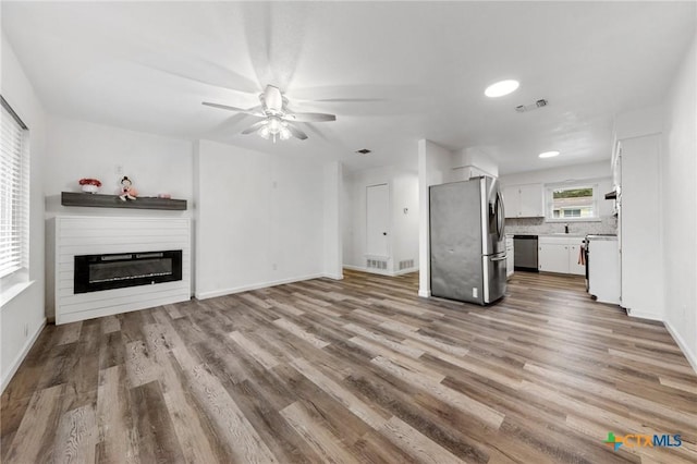 unfurnished living room featuring light hardwood / wood-style flooring and ceiling fan