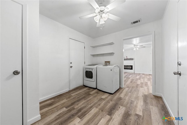 laundry area with ceiling fan, washer and clothes dryer, and wood-type flooring