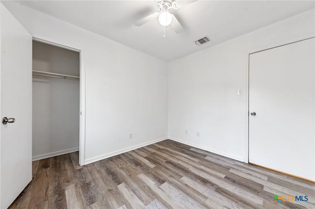 unfurnished bedroom with hardwood / wood-style floors, ceiling fan, and a closet