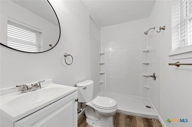 bathroom with vanity, hardwood / wood-style flooring, a shower, and toilet