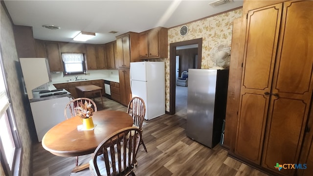 kitchen featuring hardwood / wood-style floors, sink, and white appliances