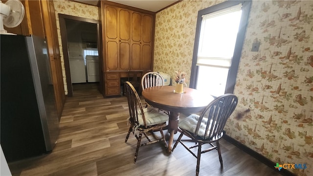 dining space with washing machine and clothes dryer, dark hardwood / wood-style floors, and a healthy amount of sunlight