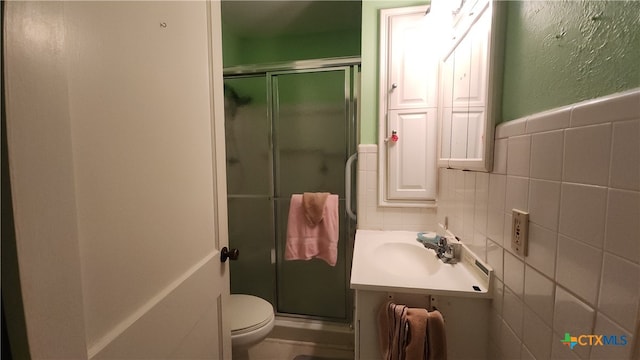 bathroom featuring tile walls, vanity, an enclosed shower, and toilet