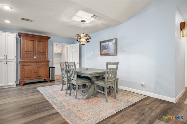 dining area with an inviting chandelier and dark hardwood / wood-style floors