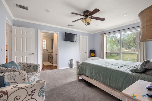 carpeted bedroom with crown molding, ceiling fan, and ensuite bath