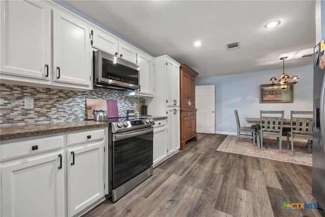 kitchen with backsplash, appliances with stainless steel finishes, dark hardwood / wood-style flooring, and white cabinets