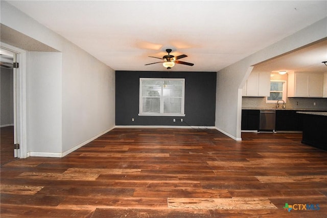 unfurnished living room with ceiling fan, dark wood-type flooring, and sink