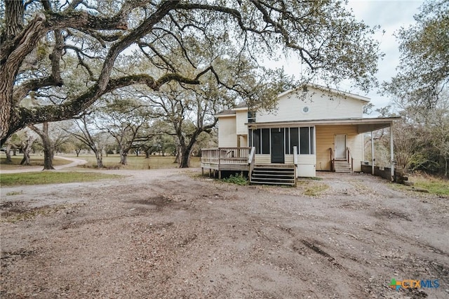 back of property featuring a sunroom and a wooden deck