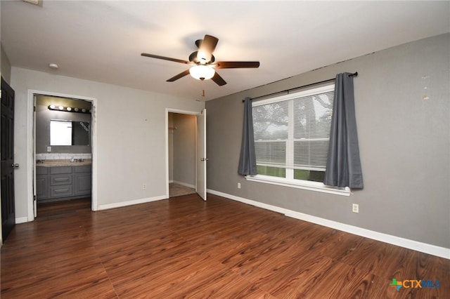 unfurnished bedroom with ensuite bathroom, ceiling fan, dark wood-type flooring, and sink