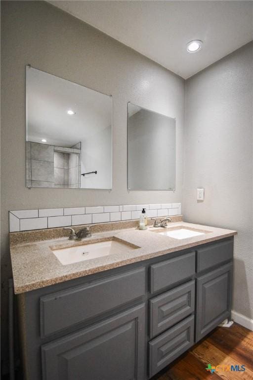 bathroom with hardwood / wood-style floors, backsplash, and vanity