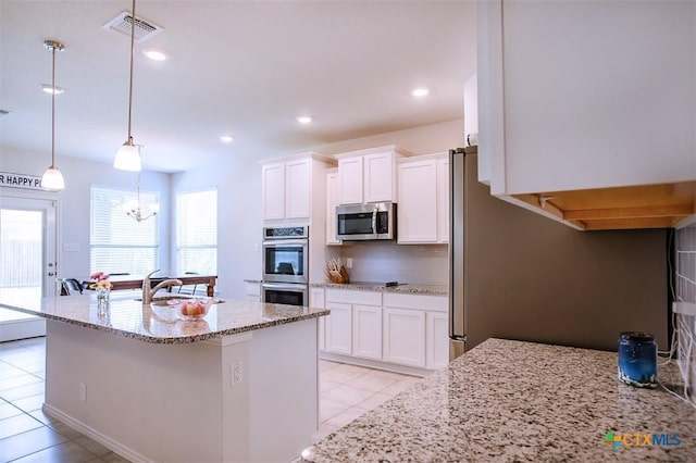 2502 Dante Ct, Harker Heights, TX 76548 - kitchen with stainless steel appliances, light tile patterned flooring, white cabinetry, light stone counters, and decorative backsplash