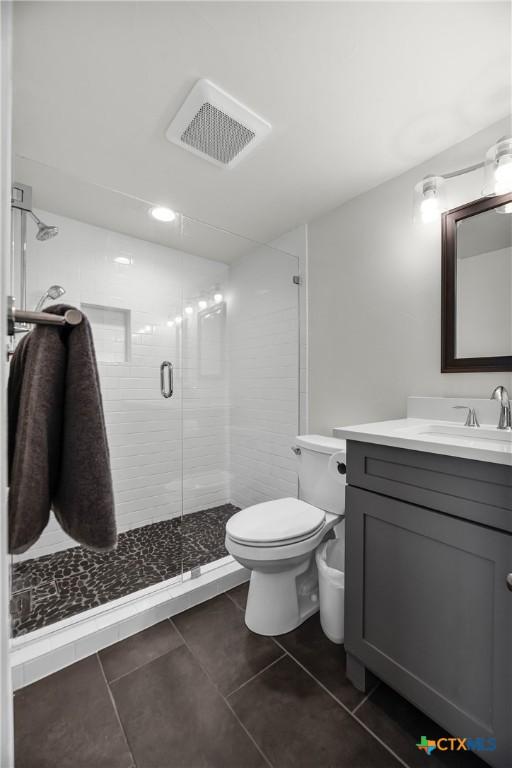 full bath featuring visible vents, toilet, a stall shower, tile patterned floors, and vanity