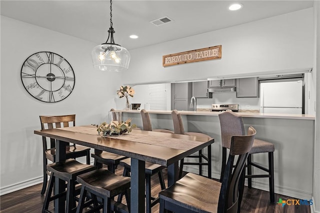 dining area with dark wood finished floors, visible vents, recessed lighting, and baseboards