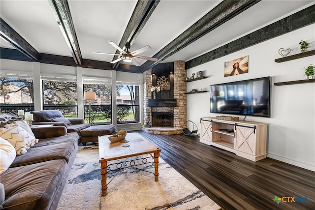 living area featuring wood finished floors, baseboards, beam ceiling, a fireplace, and ceiling fan