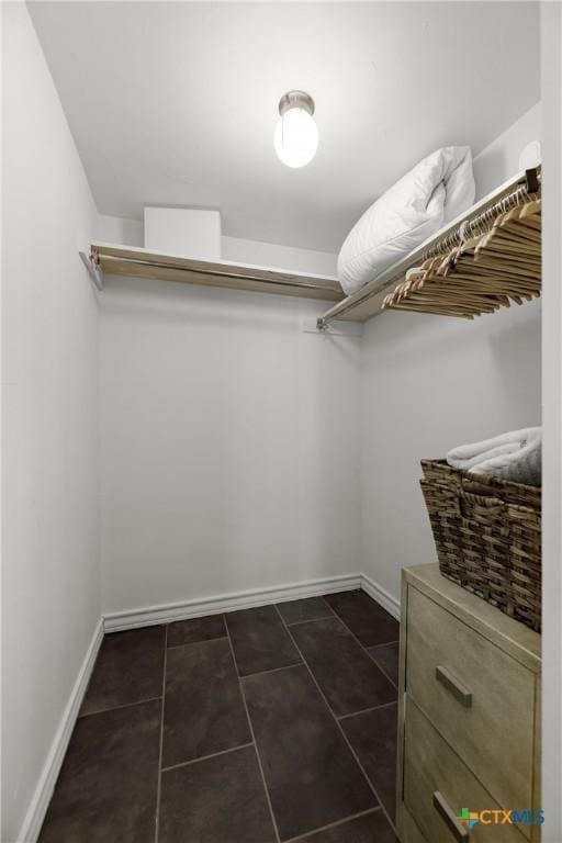 spacious closet featuring dark tile patterned floors