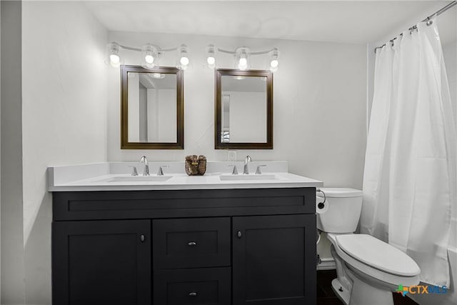 full bathroom featuring a sink, a shower with curtain, toilet, and double vanity