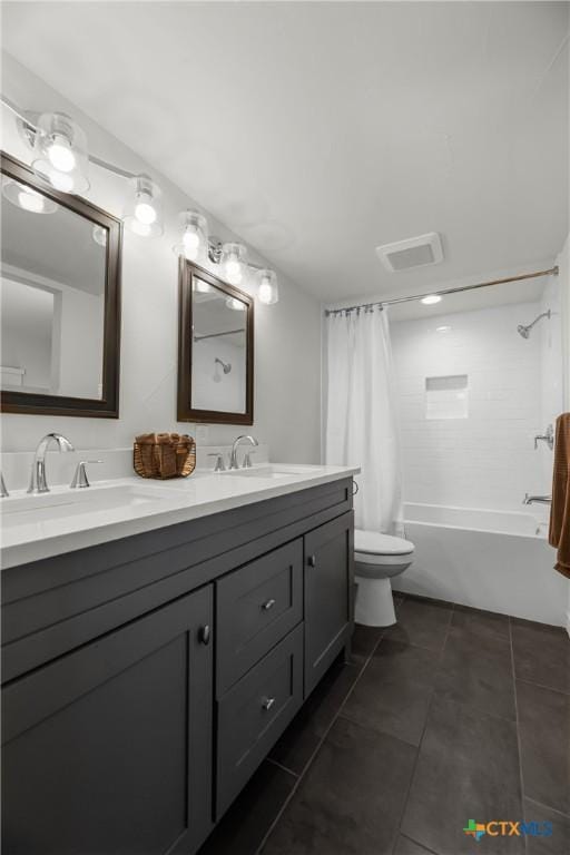 bathroom with toilet, shower / bath combo with shower curtain, double vanity, tile patterned floors, and a sink