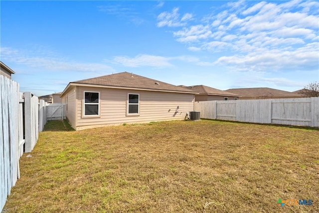 rear view of property with a yard and central AC