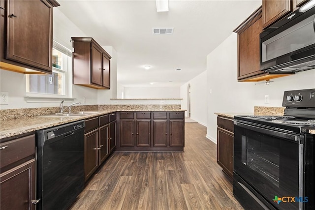 kitchen with dark hardwood / wood-style floors, black appliances, sink, dark brown cabinetry, and light stone counters