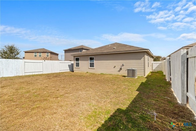 back of house featuring cooling unit and a lawn